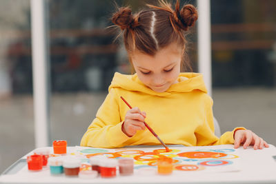 Girl holding ice cream on table