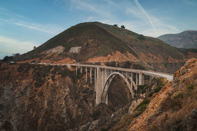Bridge over mountains against sky