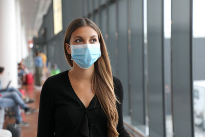 Woman wearing mask looking away in airport