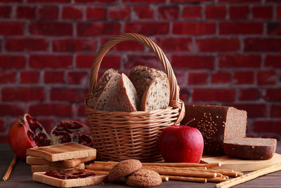 Different buns of fresh bread and spikelets of wheat on a brown vintage background