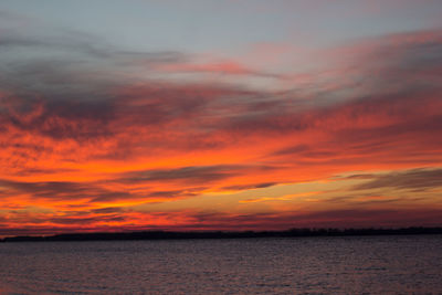 Scenic view of sea against dramatic sky during sunset