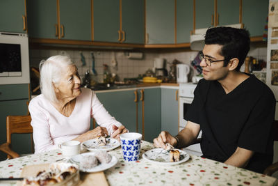 Male healthcare worker having snacks together in kitchen