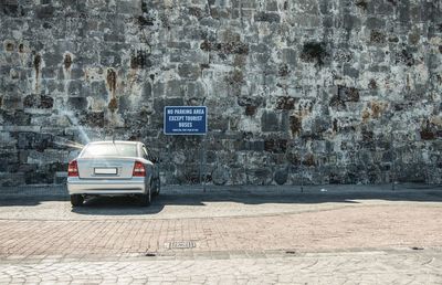 Information sign on wall by street