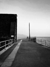 Footpath by sea against sky
