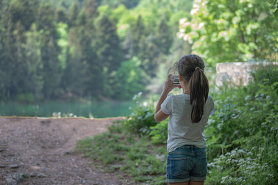 Full length of girl shooting with a small camera 