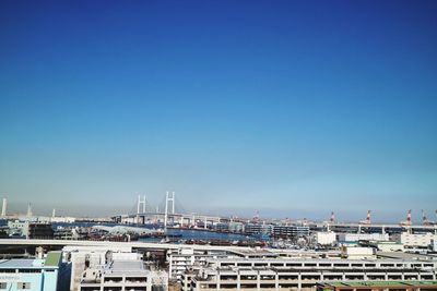 Yokohama bay bridge in city against clear sky