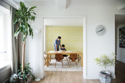 Father assisting boy with homework at home