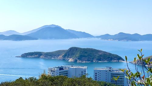 Scenic view of sea and mountains against clear sky