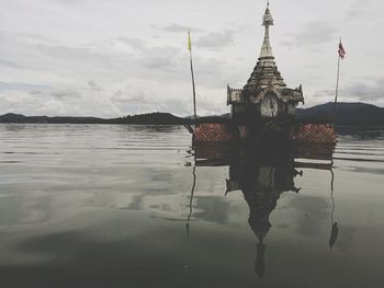 Reflection of building in lake against sky