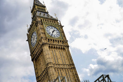 Low angle view of clock tower against cloudy sky