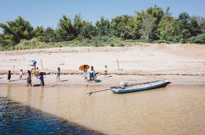 People on beach against trees