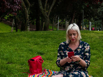 Young woman using mobile phone on field