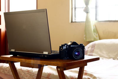 Close-up of camera and laptop on table at home