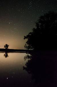 Scenic view of lake against sky at night