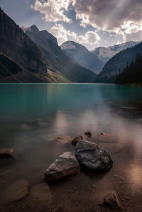 Scenic view of lake and mountains against sky during sunset