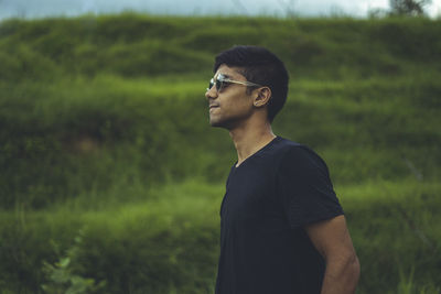 Young man wearing sunglasses standing on land
