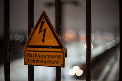 Close-up of warning sign on railing