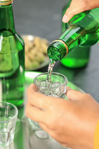 Cropped hand of person pouring drink