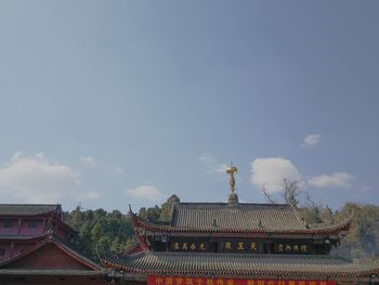 High section of temple and building against sky