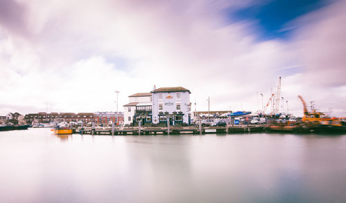 Commercial dock by buildings against sky in city