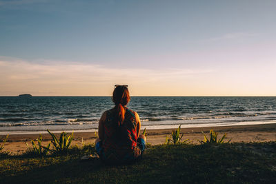 Man looking at sea against sky during sunset