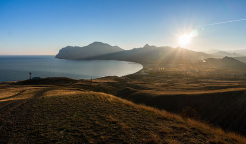 Scenic view of sea and mountains against clear sky