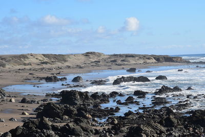 Rocks on beach against sky