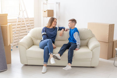 Friends sitting on sofa at home