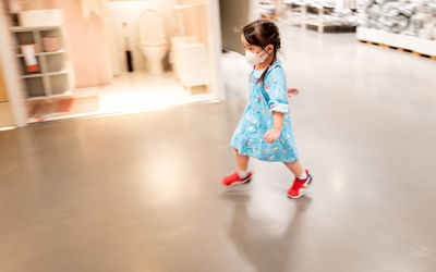 Full length of cute girl standing in mirror