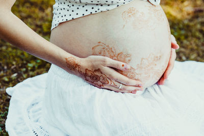 Midsection of woman with arms raised