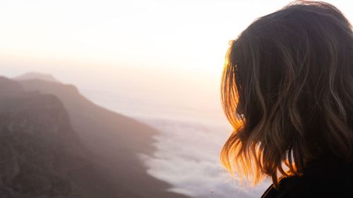 Close-up of woman against mountains and sky