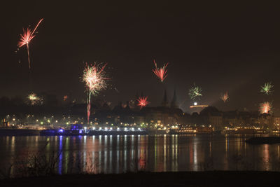 Firework display over river at night