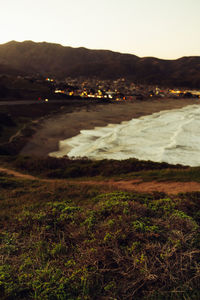 Scenic view of sea and mountains against clear sky