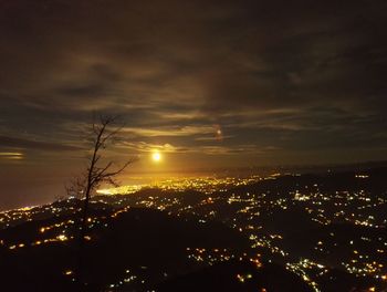 Illuminated cityscape against sky at night