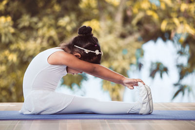 Ballet dancer exercising on floor