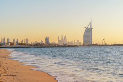 View of sea and buildings against sky during sunset