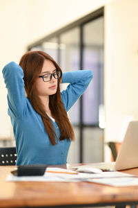 Portrait of young woman using laptop at home