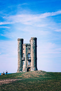 Old ruin building on field against blue sky