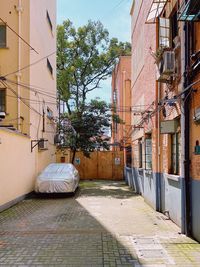 Footpath amidst buildings against sky