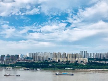 Cityscape by sea against sky