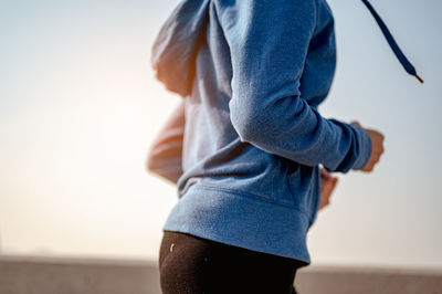 Midsection of woman standing against sky