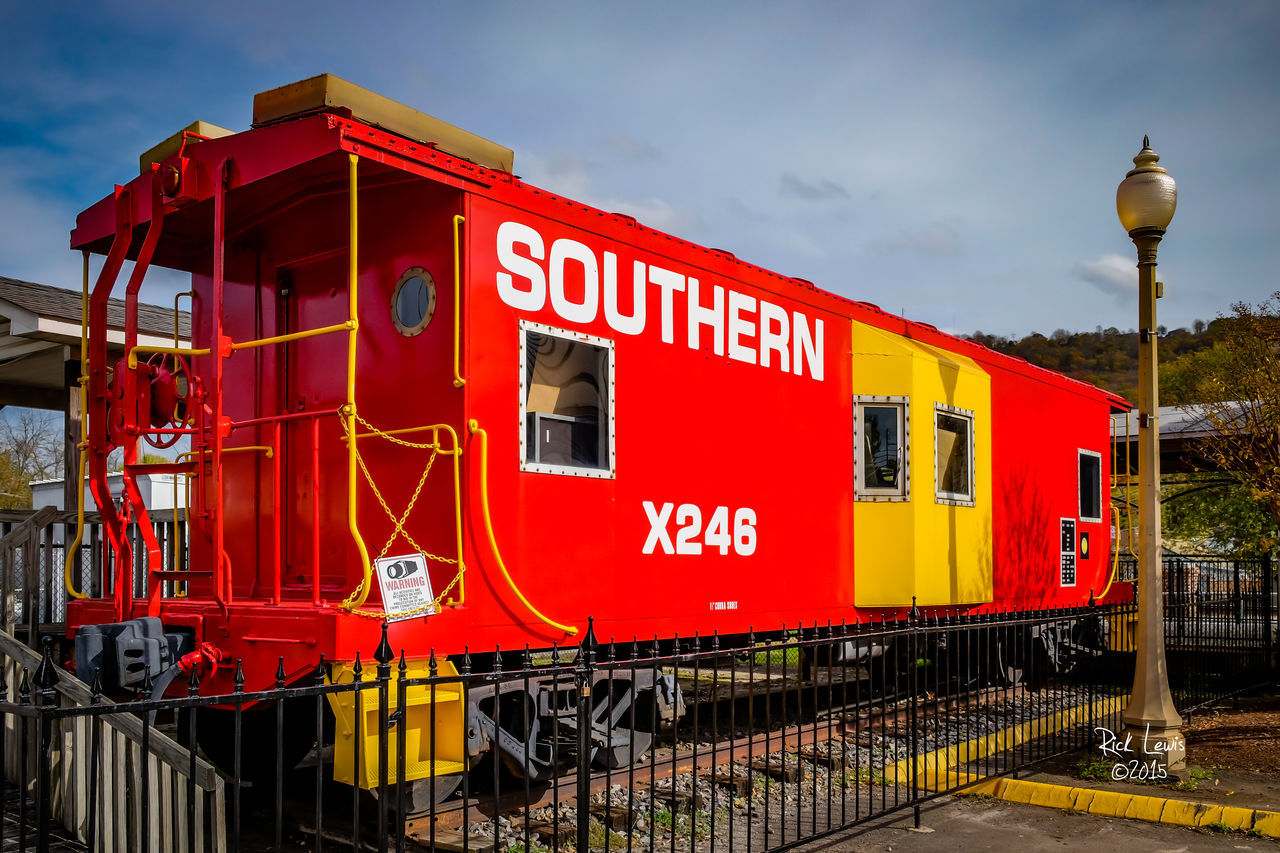 TRAIN ON RAILROAD TRACK AGAINST SKY