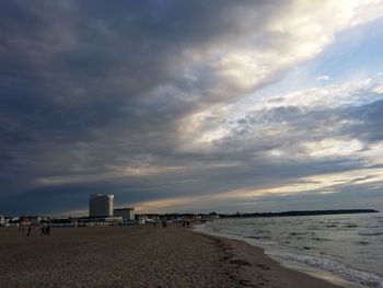 Scenic view of beach against cloudy sky