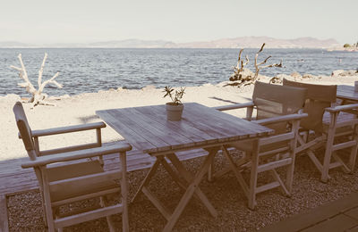 Chairs and tables on beach against sky