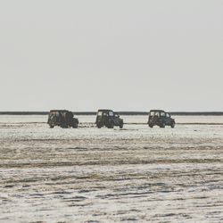 Jeeps parked on desert against sky