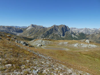 Scenic view of landscape and mountains against clear blue sky