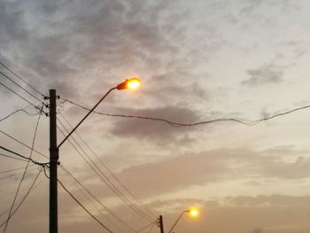 Low angle view of illuminated street light against sky