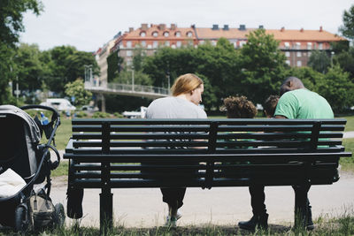 Rear view of people sitting on bench