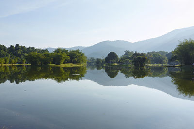 Scenic view of lake by trees against sky