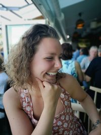 Close-up of smiling woman sitting in restaurant